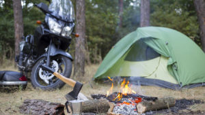MOTORCYCLE BY A CAMPFIRE AND TENT