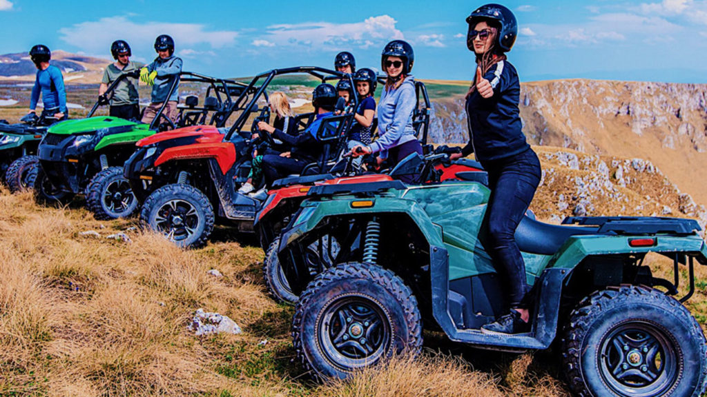 GROUP OF PEOPLE ON ATV QUAD BIKES IN MOUNTAINS
